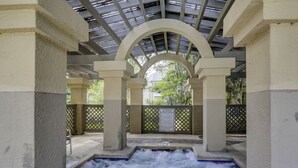 A hot tub area with a view of trees and a caution sign. - Sunset Rentals | Colonnade Club 150 (Hilton Head Island)