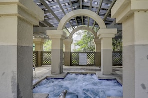 A hot tub area with a view of trees and a caution sign. - Sunset Rentals | Colonnade Club 150 (Hilton Head Island)