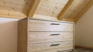 Un aparador de madera en una habitación con techo inclinado y paredes de madera.