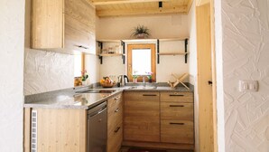 Una cocina con armarios de madera, encimera de granito y una ventana con una planta en el alféizar.