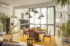 Une cuisine moderne avec un coin repas, de grandes fenêtres et une sculpture décorative représentant un cerf doré.