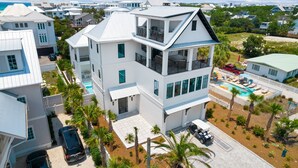 A multi-story white house with a balcony, a swimming pool, and a view of the ocean. - Bullish on Beaches|Easy Beach Access|Stunning Views|New Construction (Inlet Beach)