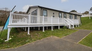 A single-story mobile home with a white deck and a small porch. - 48 Crosswinds (Bembridge)