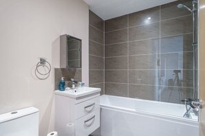 Bathtub, hair dryer, towels, shampoo