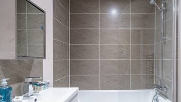 Bañera, secador de pelo, toallas, shampoo