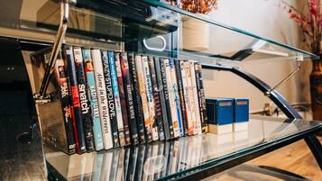 A glass shelf with a row of DVDs and two blue bookends.