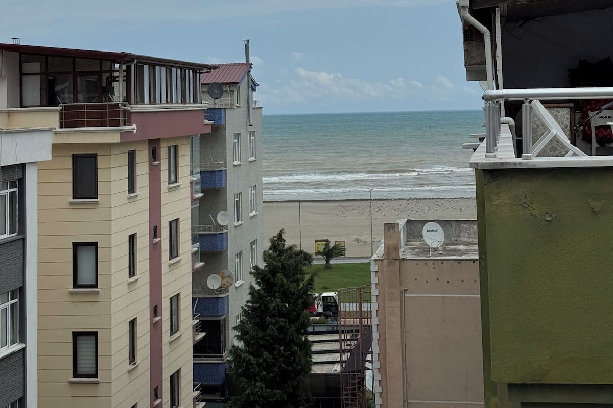Vista costeira com praia e oceano ao fundo.