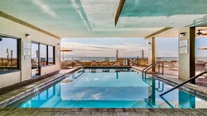 An indoor swimming pool with clear views of the beach and ocean.