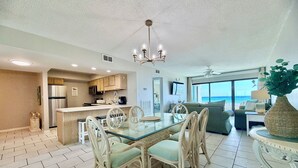 A modern kitchen with a dining area, a living room with a view, and a large window.