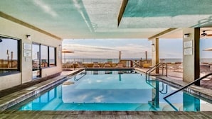 An indoor swimming pool with clear views of the beach and ocean.
