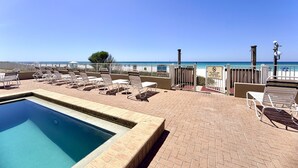 A pool area with lounge chairs and a view of the beach. - Gulfgate 403 - Beautiful Pet Friendly 2 Bed Condo (PANAMA CITY Beach)