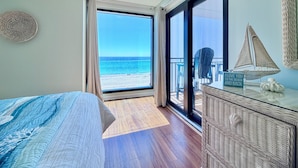 A bedroom with a large sliding glass door leading to a balcony with a view of the beach. - Gulfgate 403 - Beautiful Pet Friendly 2 Bed Condo (PANAMA CITY Beach)