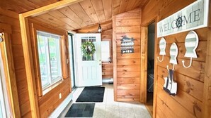 A wooden hallway with a 'WELCOME' sign, a door with a wreath, and a 'WELCOME' sign on the wall. - ANNABESSACOOK WATERFRONT WITH DOCK (Winthrop)
