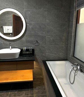 Deluxe suite | Badkamer | Een aparte badkuip en douche, een regendouche, een haardroger