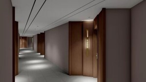 Un couloir avec des portes en bois et un luminaire fixé au mur.