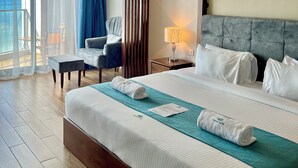 Une chambre d’hôtel avec un grand lit, un bureau, une chaise, une table de chevet et une vue sur l’extérieur.