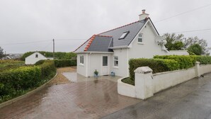 A white house with a red-tiled roof, a satellite dish, and a paved driveway. - Tí Coilín Mhac (Maumeen)