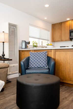 A modern kitchen with wooden cabinets, a black countertop, and a microwave.