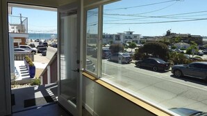 A view from a balcony with a clear street and parked cars in the background. - Harbor House A, overlooking Santa Cruz Harbor (Santa Cruz)
