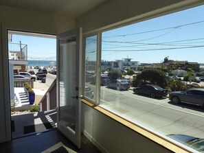 Blick vom Balkon auf eine klare Straße und geparkte Autos im Hintergrund.