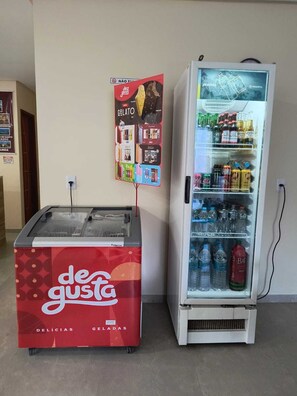 A vending machine with a variety of beverages and a freezer unit labeled 'de gusta' with ice cream and gelato options. - Pousada Donna Maraka (Ipojuca)