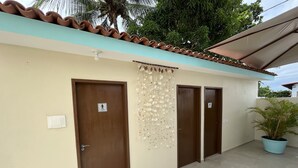 A hotel corridor with three doors, each marked with a "hotel room" sign, a tiled floor, and a potted plant in the corner. - Pousada Donna Maraka (Ipojuca)