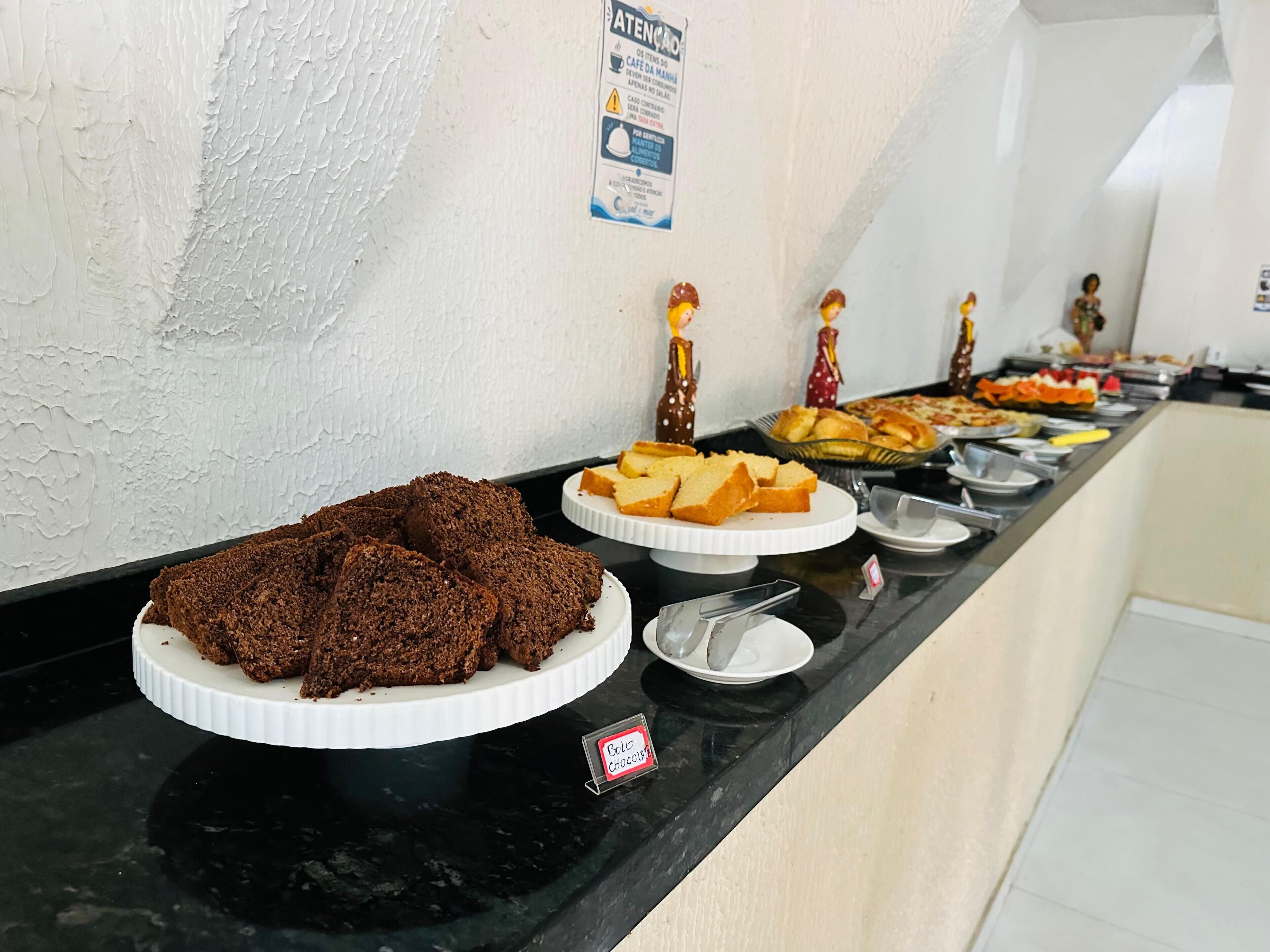 Un bufé con diferentes opciones de comida, incluyendo brownies y pan.