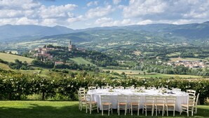 A table set for six with a view of a town and mountains in the background. - Agriturismo Vecchia Quercia (Poppi)