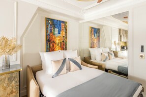 A hotel room with a large bed, a nightstand, a mirror, and a painting on the wall.