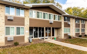 A multi-story building with a flat roof, large windows, and a central entrance.