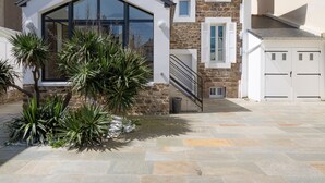 Ein Gebäude aus Stein mit modernem Design, das ein großes Glasfenster und eine Treppe zum Eingang zeigt.