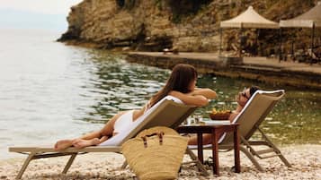 Relax in comfort on the pebbled surface with two lounge chairs and a nearby woven basket.