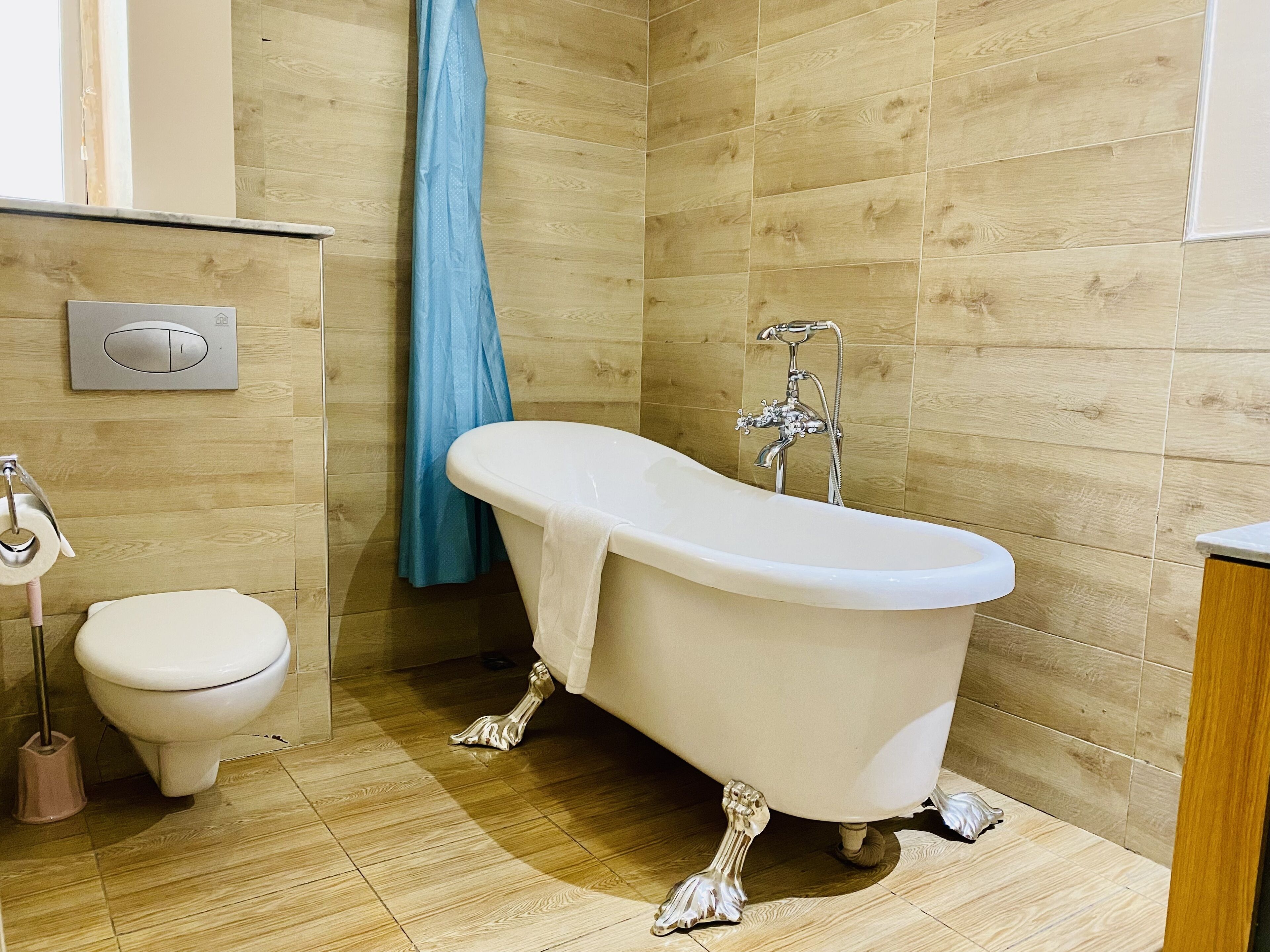A bathroom with a white bathtub, a toilet, and a shower.