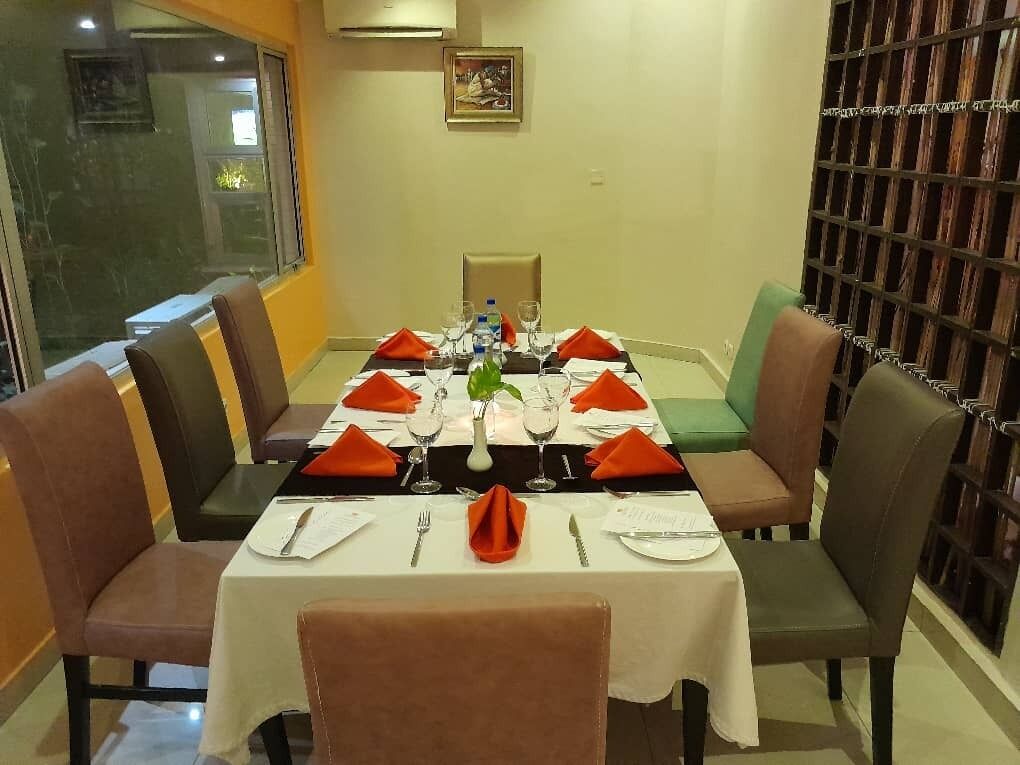 A dining area with a rectangular table set for four, surrounded by chairs.
