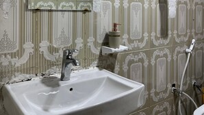 Ein Badezimmer mit Waschbecken, Spiegel, Toilette und Handtuchhalter.
