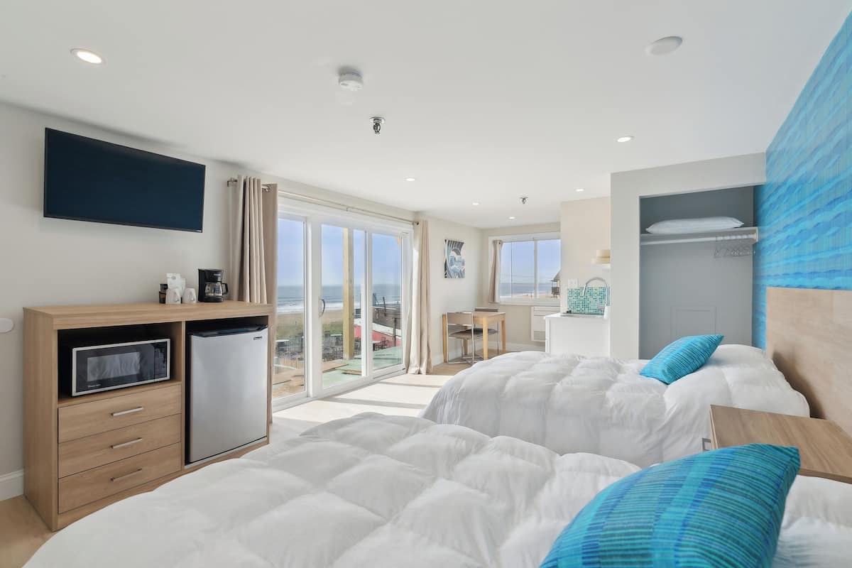Habitación de hotel con dos camas, un escritorio, un microondas y un refrigerador.