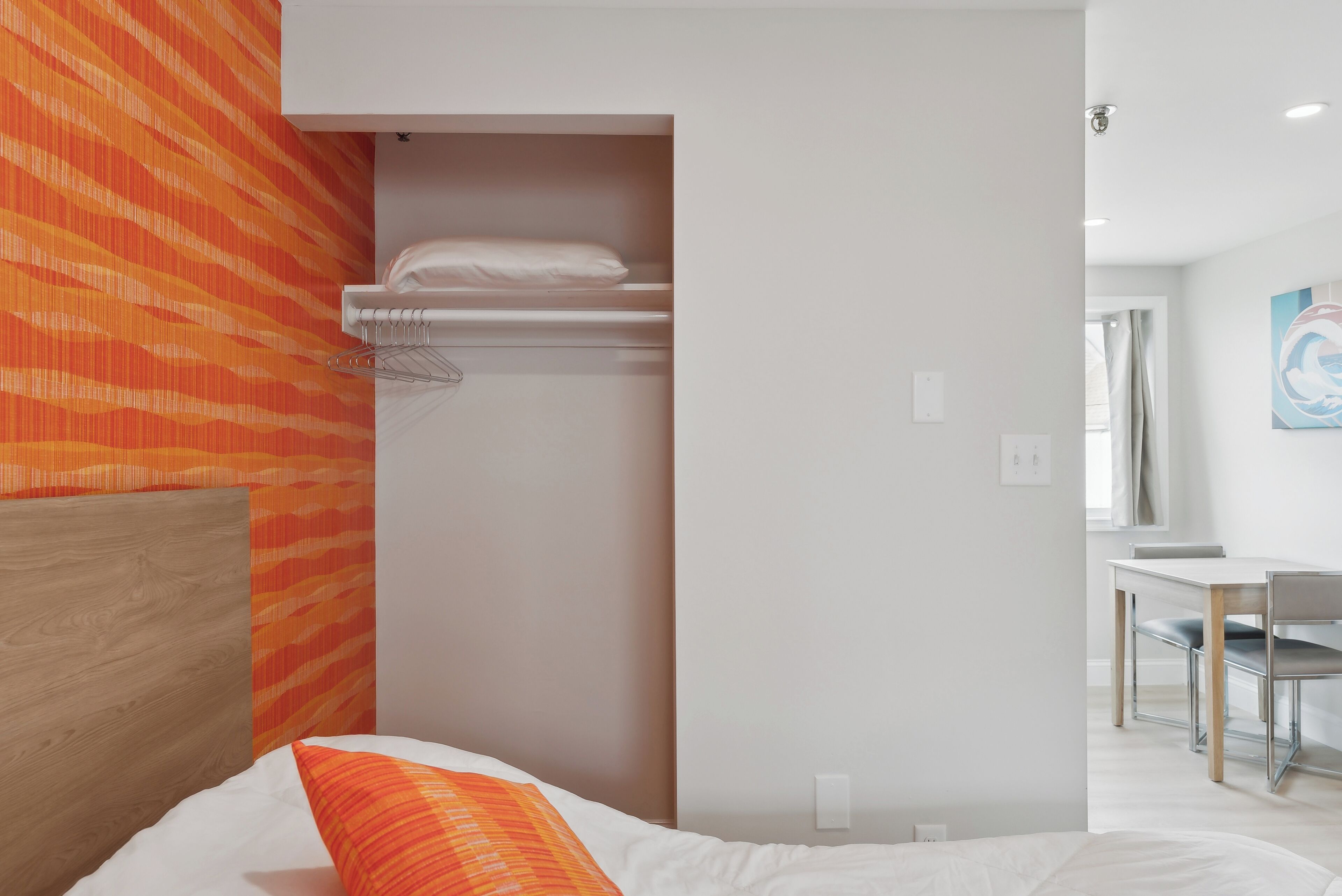 Une chambre d’hôtel comprenant un lit, une armoire et un bureau avec des chaises.