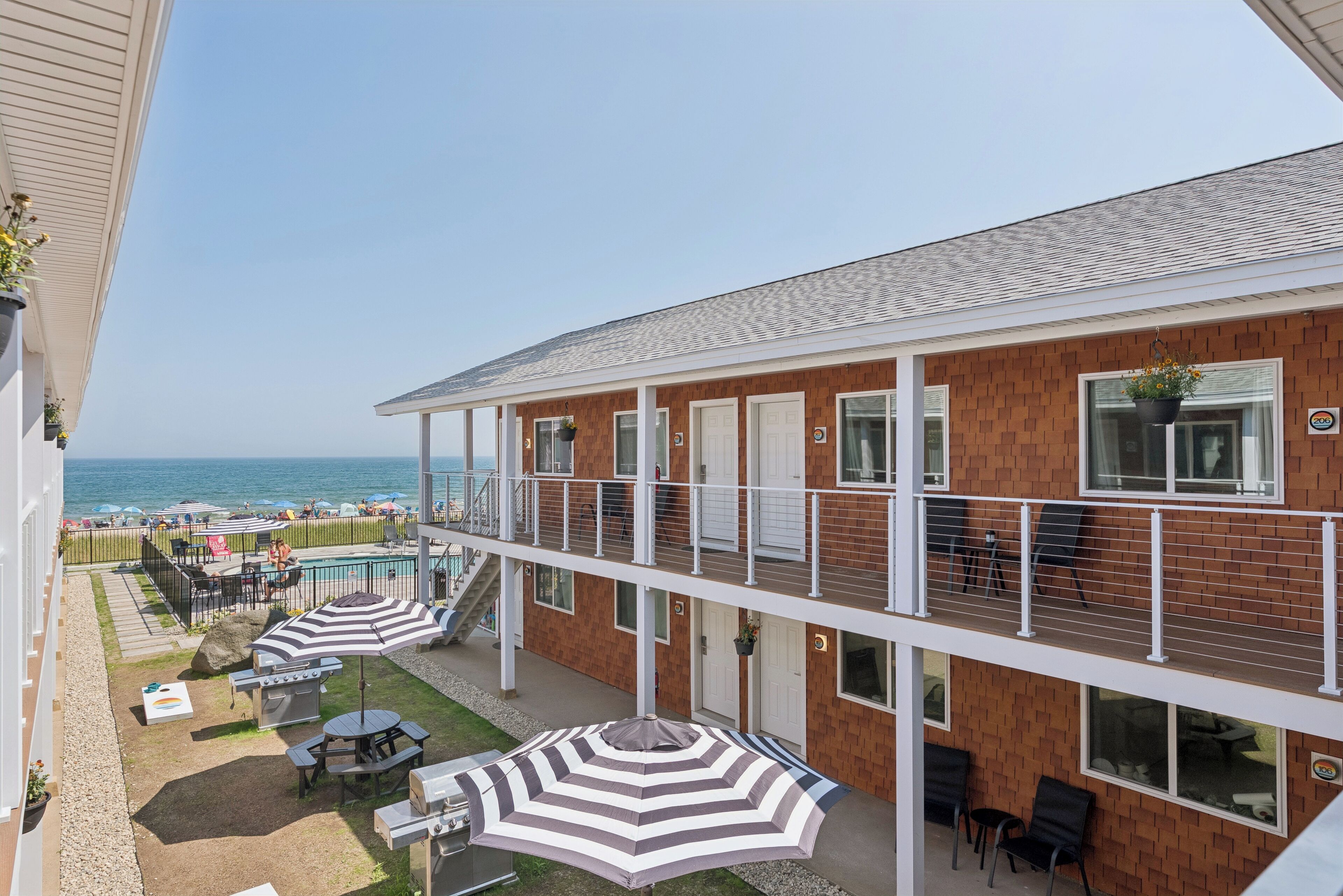 Un hotel con piscina, mobiliario exterior y vistas a la playa.
