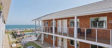 Un hotel con piscina, mobiliario exterior y vistas a la playa.