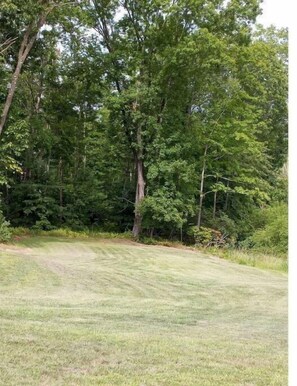 Enjoy a serene stroll through the lush, grassy grounds surrounded by a variety of trees.