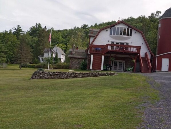 Stunning two-story house with a spacious balcony and beautifully manicured lawn.