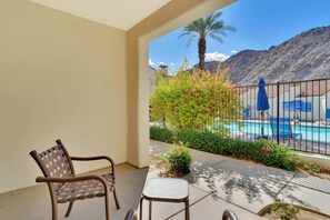 A balcony with a pool, chairs, and a view of a mountain. - Desert Oasis B | Studio Legacy Villa (La Quinta)