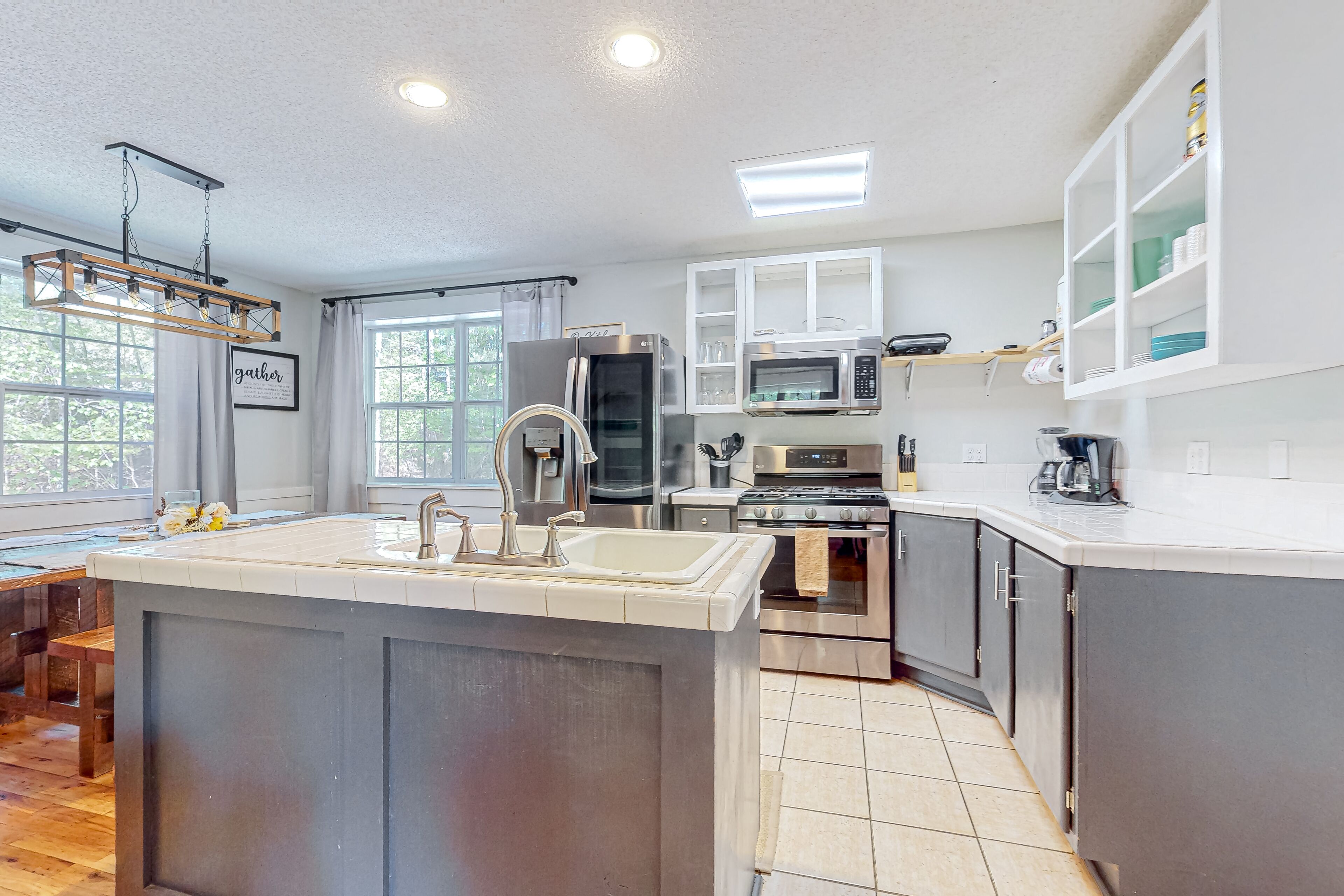 Charming home lined by trees with a large deck, grill, firepit, & pool table