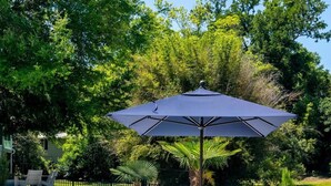 A poolside area with lounge chairs, a table, and an umbrella. - Church St Collection - 109 Full House (Fairhope)
