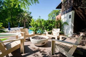 A wooden deck with lounge chairs, a fire pit, and a pool in the background. - Church St Collection - 109 Upper Levels (Fairhope)