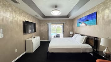 Quarto de hotel com uma cama, televisão, um quadro e vista para o exterior.