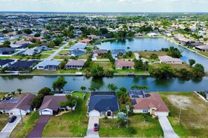 A residential area with houses, a lake, and a clear sky.