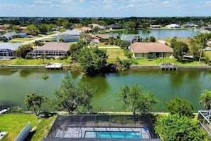 A residential area with a swimming pool, houses, and a lake.