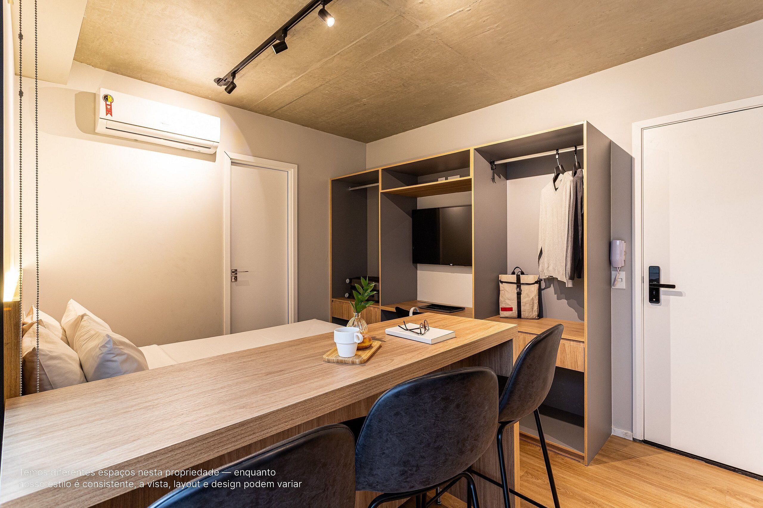 Ein modernes Zimmer mit einem Holztisch, Stühlen, einem Kleiderschrank und einem Kleiderhaken.