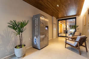 A reception area with a modern design, including a reception desk, a potted plant, and seating area.
